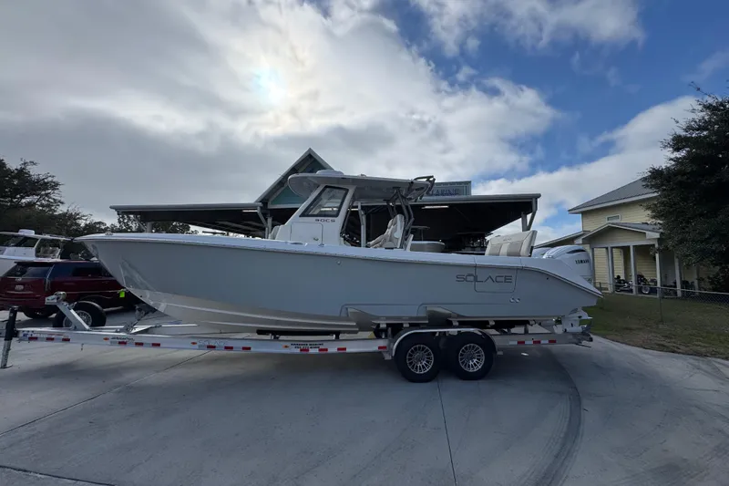 The Image of 2026 Solace 30 CS boat on trailer, parked outdoors under cloudy sky. - 1