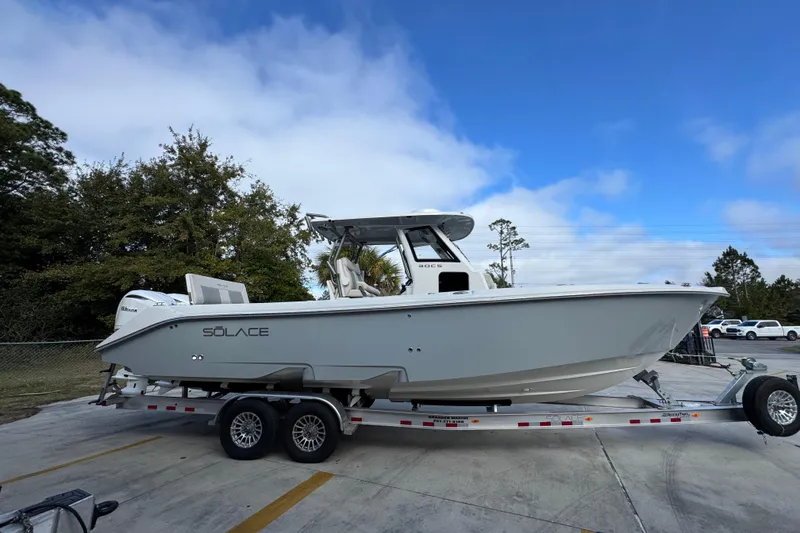 Slide: The Image of 2026 Solace 30 CS boat on trailer, parked outdoors under blue sky. - 10
