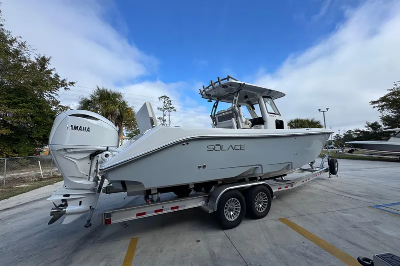 Slide: The Image of 2026 Solace 30 CS boat on trailer with Yamaha engine, parked outdoors. - 11