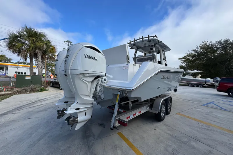 Slide: The Image of 2026 Solace 30 CS boat with Yamaha engines on a trailer in a parking lot. - 12