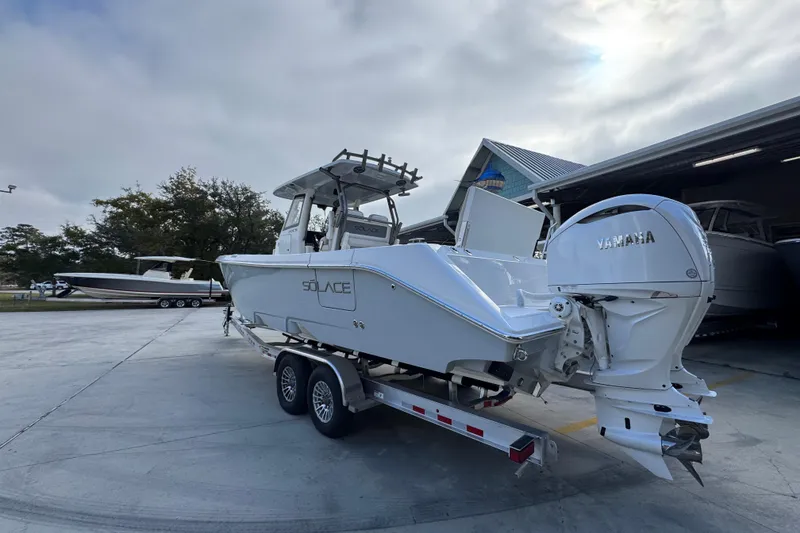 Slide: The Image of 2026 Solace 30 CS boat on trailer with Yamaha engine, parked outdoors. - 16