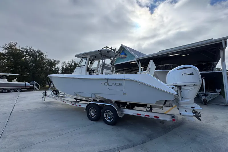 Slide: The Image of 2026 Solace 30 CS boat on trailer with Yamaha engine, parked outdoors. - 17