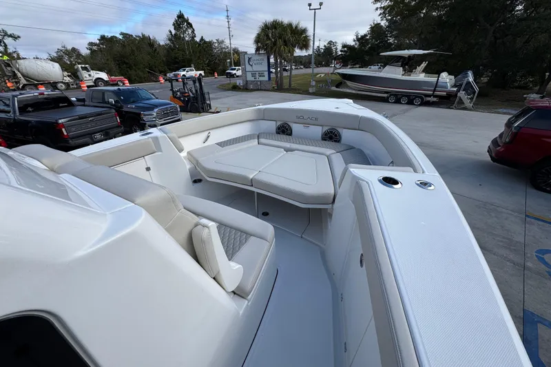 Slide: The Image of 2026 Solace 30 CS boat with spacious seating and modern design in a parking area. - 18