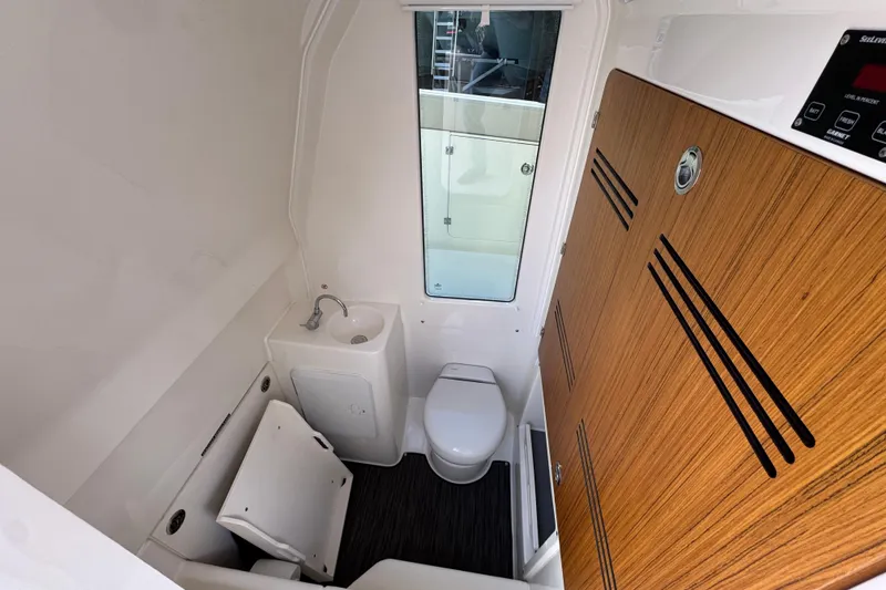 Slide: The Image of Interior of 2026 Solace 30 CS boat bathroom with sink, toilet, and wooden accents. - 28