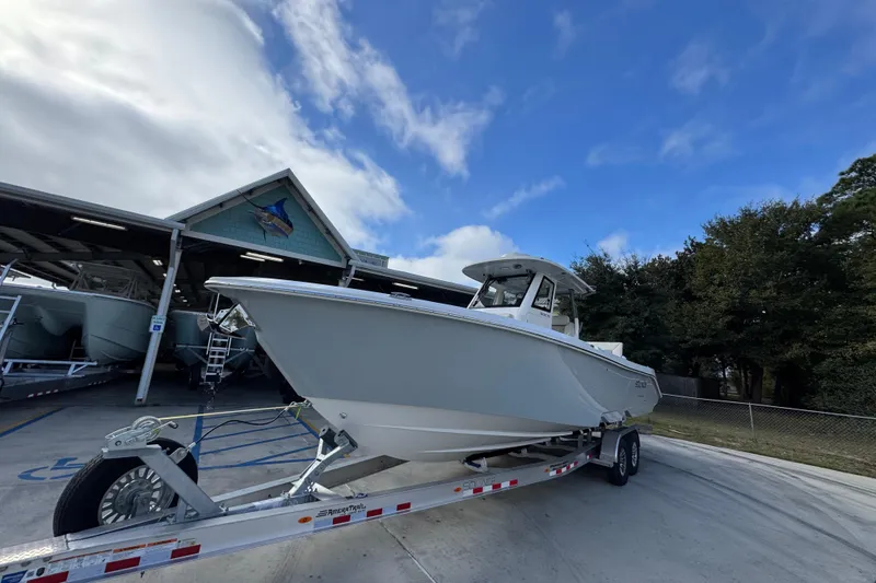 Slide: The Image of 2026 Solace 30 CS boat on trailer under blue sky near storage facility. - 4