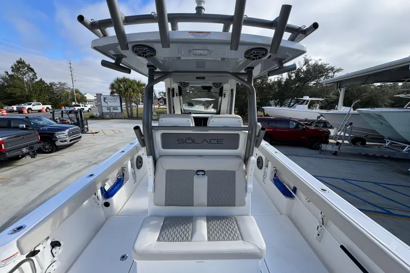 Slide: The Image of 2026 Solace 30 CS boat interior with seating and storage, parked outdoors. - 40