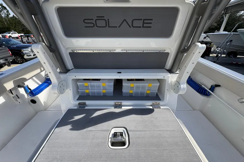 Slide: The Image of 2026 Solace 30 CS boat storage compartment with organized tackle boxes and sleek design. - 42