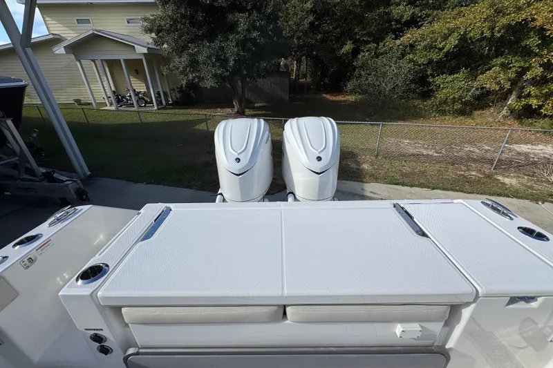 Slide: The Image of 2026 Solace 30 CS boat with dual outboard engines, parked near a house. - 47