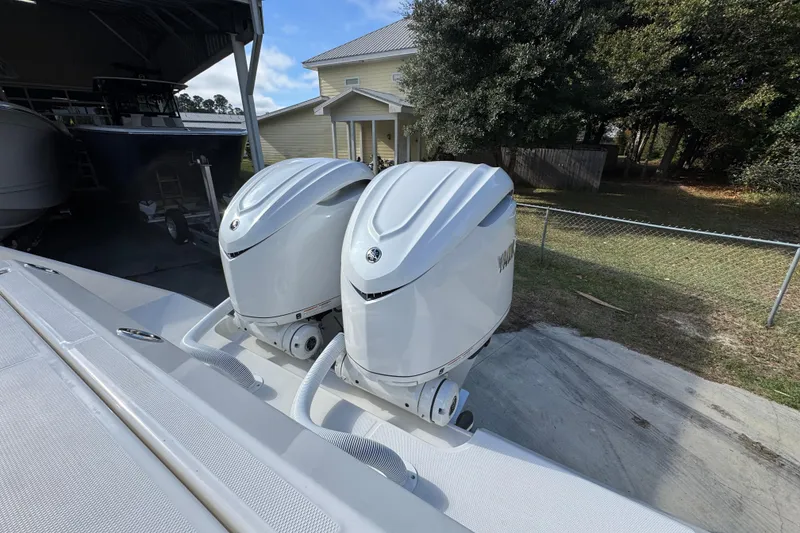 Slide: The Image of Twin outboard engines on a 2026 Solace 30 CS boat, parked near a house. - 48