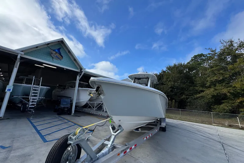 Slide: The Image of 2026 Solace 30 CS boat on trailer outside a storage facility under a blue sky. - 5