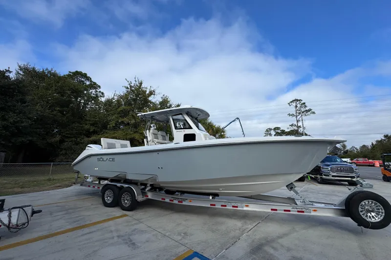 Slide: The Image of 2026 Solace 30 CS boat on trailer, parked outdoors under a blue sky. - 9
