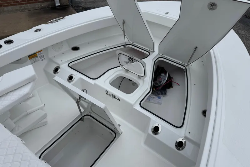 Slide: The Image of Open storage compartments on a 2026 BlackJack 256 Coastal boat deck. - 11