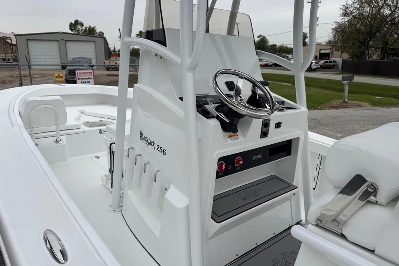Slide: The Image of 2026 BlackJack 256 Coastal boat interior with steering console and seating. - 14