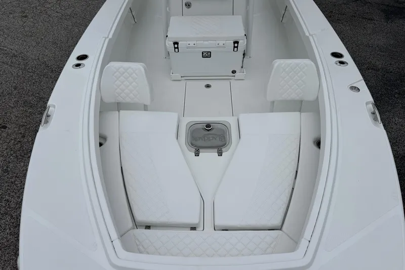 Slide: The Image of 2026 BlackJack 256 Coastal boat interior with white seating and storage compartments. - 7