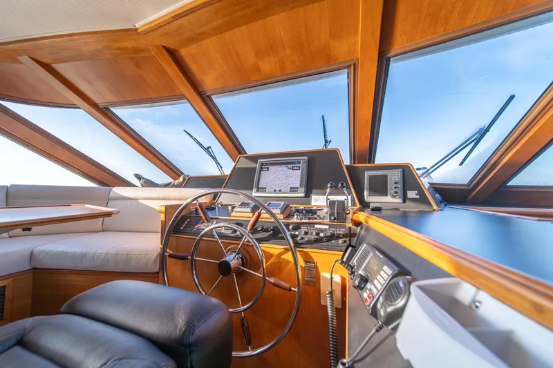 Slide: The Image of 1991 Tollycraft 57 Pilothouse Motor Yacht helm with navigation equipment and panoramic windows. - 19