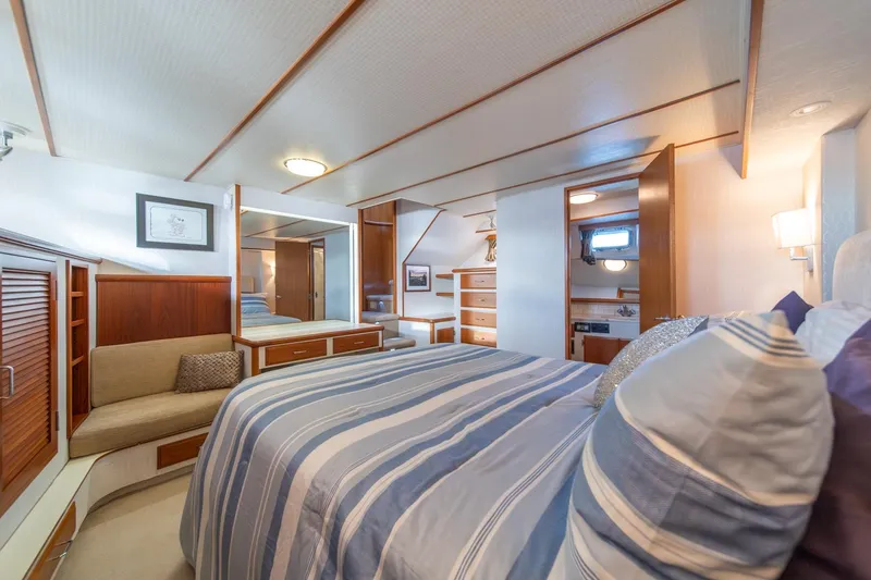Slide: The Image of Luxurious bedroom interior of 1991 Tollycraft 57 Pilothouse Motor Yacht with striped bedding. - 25