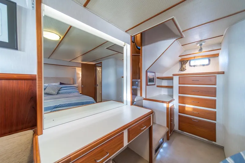 Slide: The Image of 1991 Tollycraft 57 Pilothouse Motor Yacht interior with bedroom, vanity, and wooden cabinetry. - 26