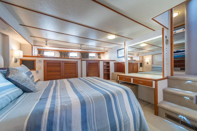 Slide: The Image of Luxurious bedroom interior of 1991 Tollycraft 57 Pilothouse Motor Yacht with striped bedding. - 29