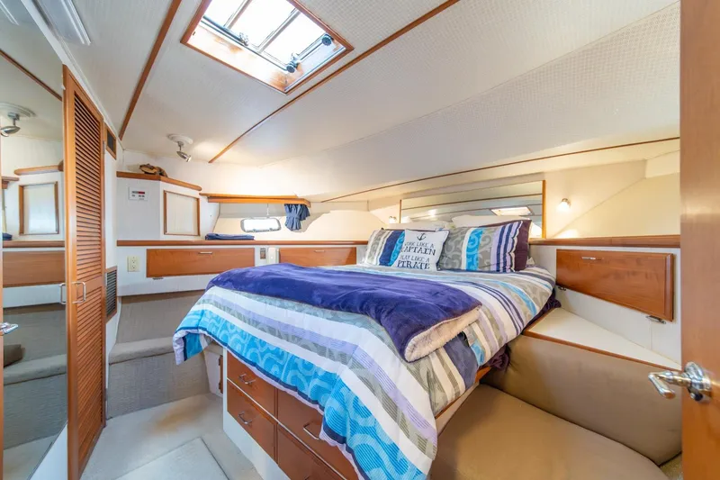 Slide: The Image of Luxurious bedroom interior of 1991 Tollycraft 57 Pilothouse Motor Yacht with cozy bedding. - 32