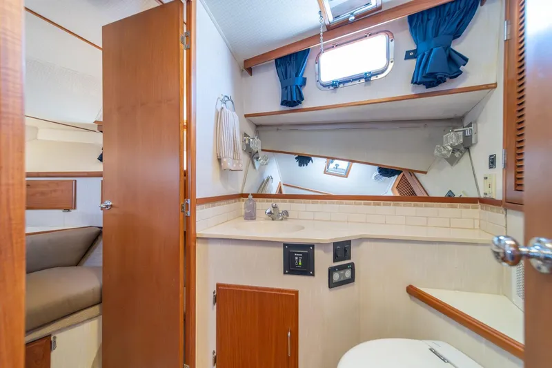 Slide: The Image of 1991 Tollycraft 57 Pilothouse Motor Yacht bathroom with sink, mirror, and wooden cabinetry. - 36