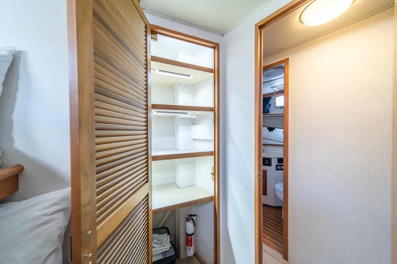 Slide: The Image of Interior of 1991 Tollycraft 57 Pilothouse Motor Yacht with open closet and bathroom view. - 42