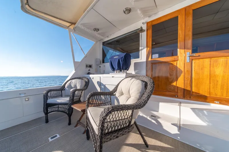 Slide: The Image of 1991 Tollycraft 57 Pilothouse Motor Yacht deck with wicker chairs and ocean view. - 45