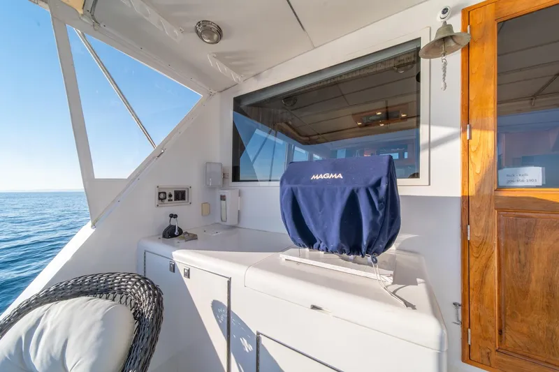 Slide: The Image of 1991 Tollycraft 57 Pilothouse Motor Yacht deck with covered grill and ocean view. - 46