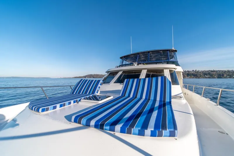 Slide: The Image of 1991 Tollycraft 57 Pilothouse Motor Yacht with striped deck chairs on open water. - 50