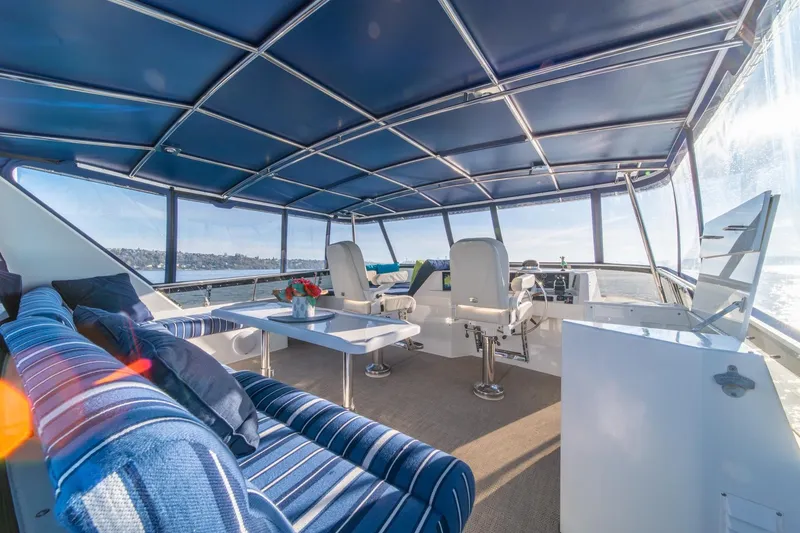 Slide: The Image of Luxurious 1991 Tollycraft 57 Pilothouse Motor Yacht interior with blue seating and panoramic views. - 52
