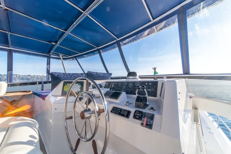 Slide: The Image of 1991 Tollycraft 57 Pilothouse Motor Yacht helm with blue canopy and scenic view. - 53