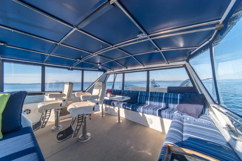Slide: The Image of Luxurious interior of 1991 Tollycraft 57 Pilothouse Motor Yacht with blue seating and ocean view. - 56