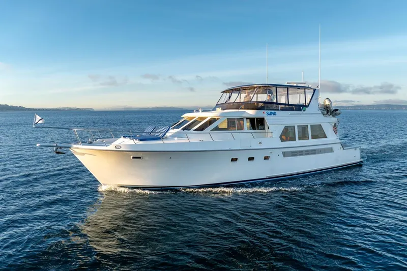 Slide: The Image of 1991 Tollycraft 57 Pilothouse Motor Yacht cruising on open water under clear skies. - 65