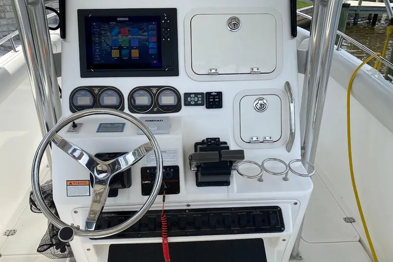 Slide: The Image of Center console of a 2005 Century 2900 boat with steering wheel and navigation controls. - 10