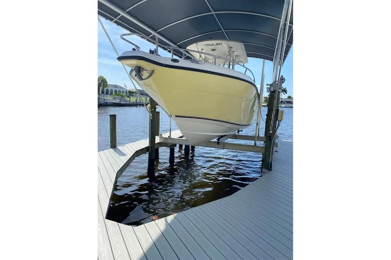 Slide: The Image of 2005 Century 2900 Center Console boat on lift, docked by waterfront. - 2
