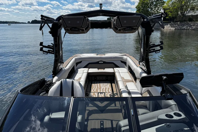 Slide: The Image of 2023 Centurion Ri265 boat interior with luxurious seating on a serene lake. - 15