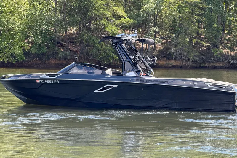Slide: The Image of 2023 Centurion Ri265 boat on a calm lake with forested background. - 7