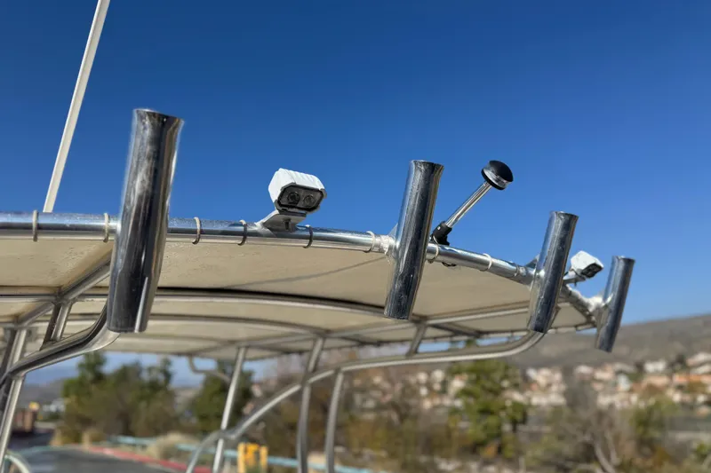 Slide: The Image of Close-up of 2022 Sailfish 242 CC boat's rod holders and equipment under clear blue sky. - 10