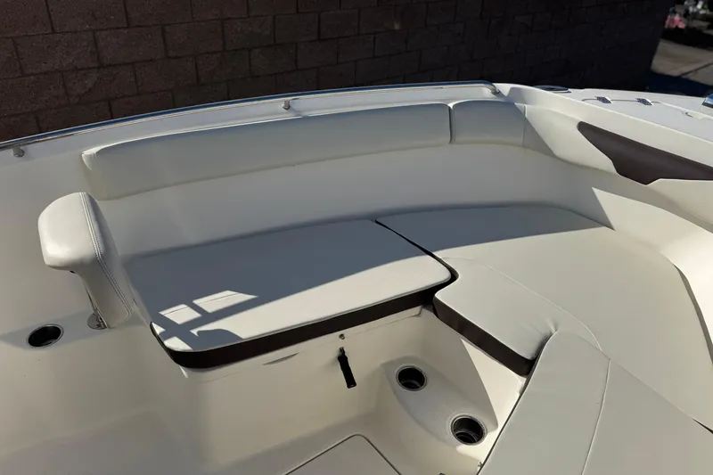 Slide: The Image of 2022 Sailfish 242 CC boat interior with cushioned seating and cup holders. - 12