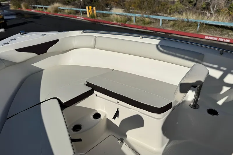 Slide: The Image of 2022 Sailfish 242 CC boat interior with cushioned seating and cup holders. - 13