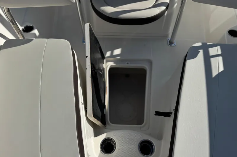 Slide: The Image of Open storage compartment on 2022 Sailfish 242 CC boat deck, surrounded by cushioned seating. - 18