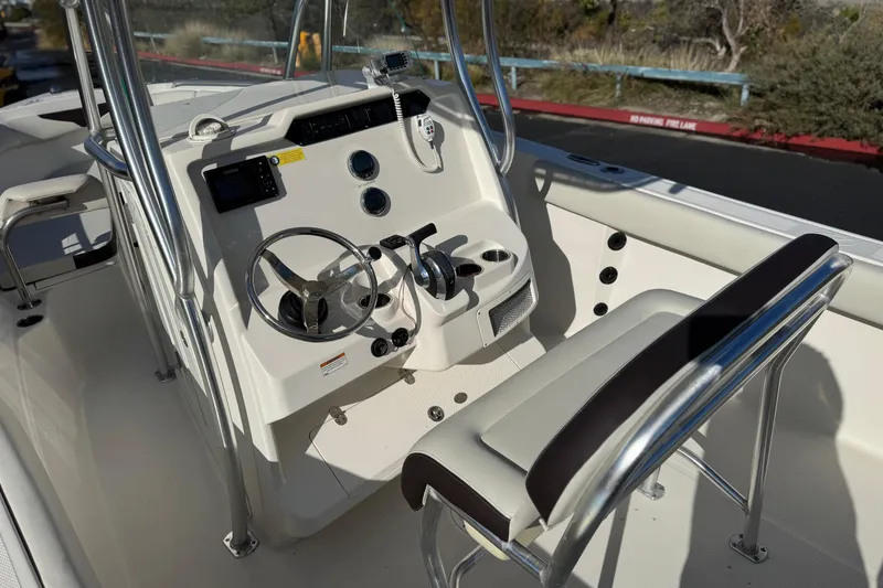 Slide: The Image of 2022 Sailfish 242 CC boat cockpit with steering wheel and controls. - 24