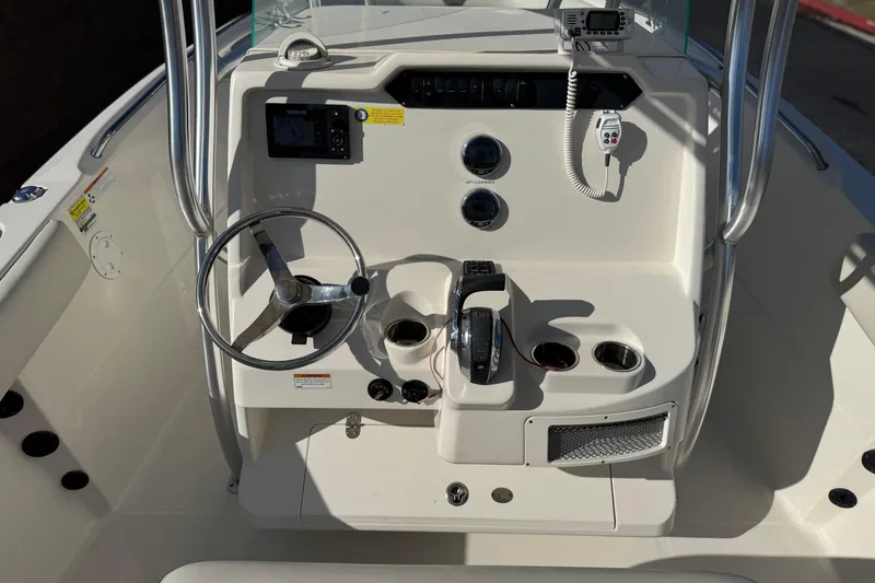 Slide: The Image of 2022 Sailfish 242 CC boat console with steering wheel, controls, and navigation equipment. - 25