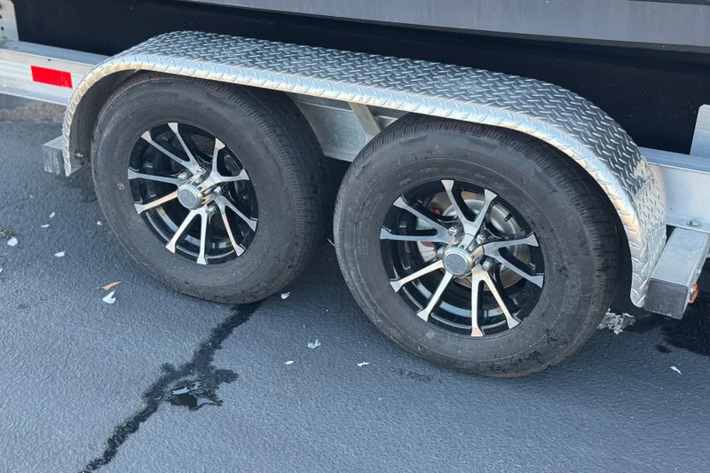 Slide: The Image of Trailer wheels for 2022 Sailfish 242 CC boat on asphalt surface. - 30