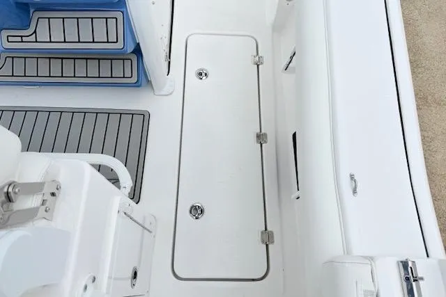 Slide: The Image of 2026 Tidewater 256 CC Adventure boat deck with storage hatch and seating. - 10