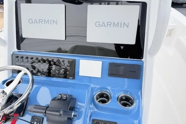 Slide: The Image of 2026 Tidewater 256 CC Adventure boat dashboard with dual Garmin displays and controls. - 12