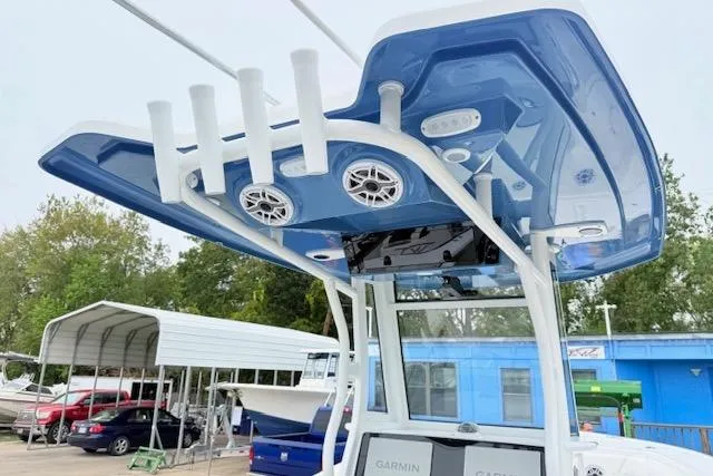 Slide: The Image of 2026 Tidewater 256 CC Adventure boat with blue T-top and rod holders. - 7