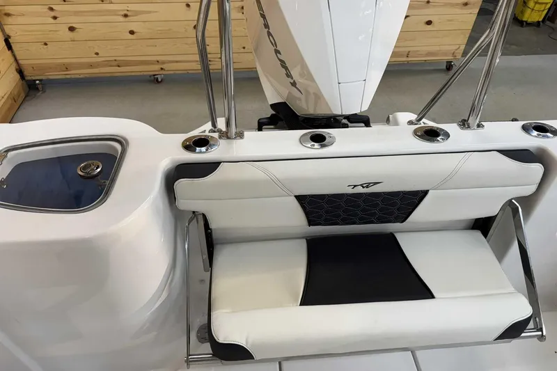 Slide: The Image of 2025 Tidewater 232 CC Adventure boat interior with cushioned seating and rod holders. - 11