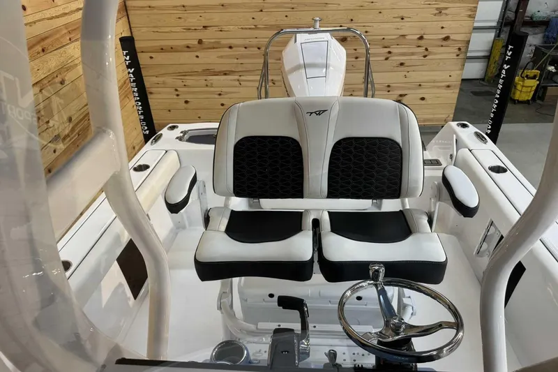 Slide: The Image of 2025 Tidewater 232 CC Adventure boat interior with dual seats and steering wheel. - 12