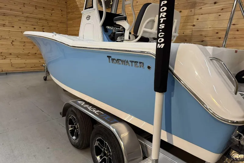 Slide: The Image of 2025 Tidewater 232 CC Adventure boat in showroom, featuring sleek blue and white design. - 4