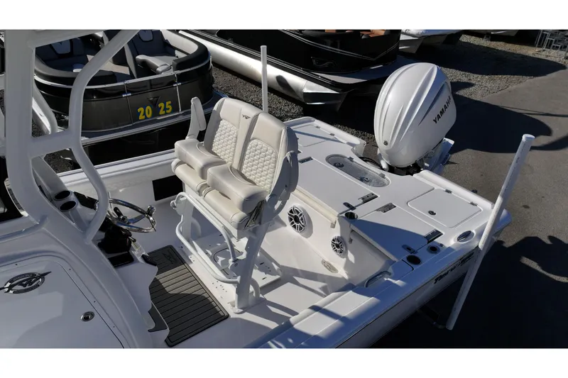 Slide: The Image of 2026 Tidewater 2500 Carolina Bay boat on trailer, parked near a lake with trees. - 4